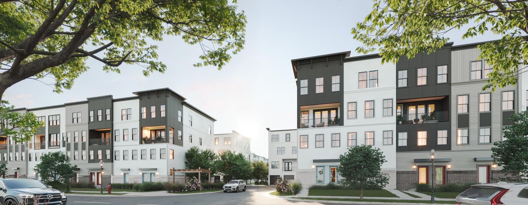 The exterior of the Pax Place townhomes for rent in Sterling, VA, featuring a modern facade and parking spots with cars.
