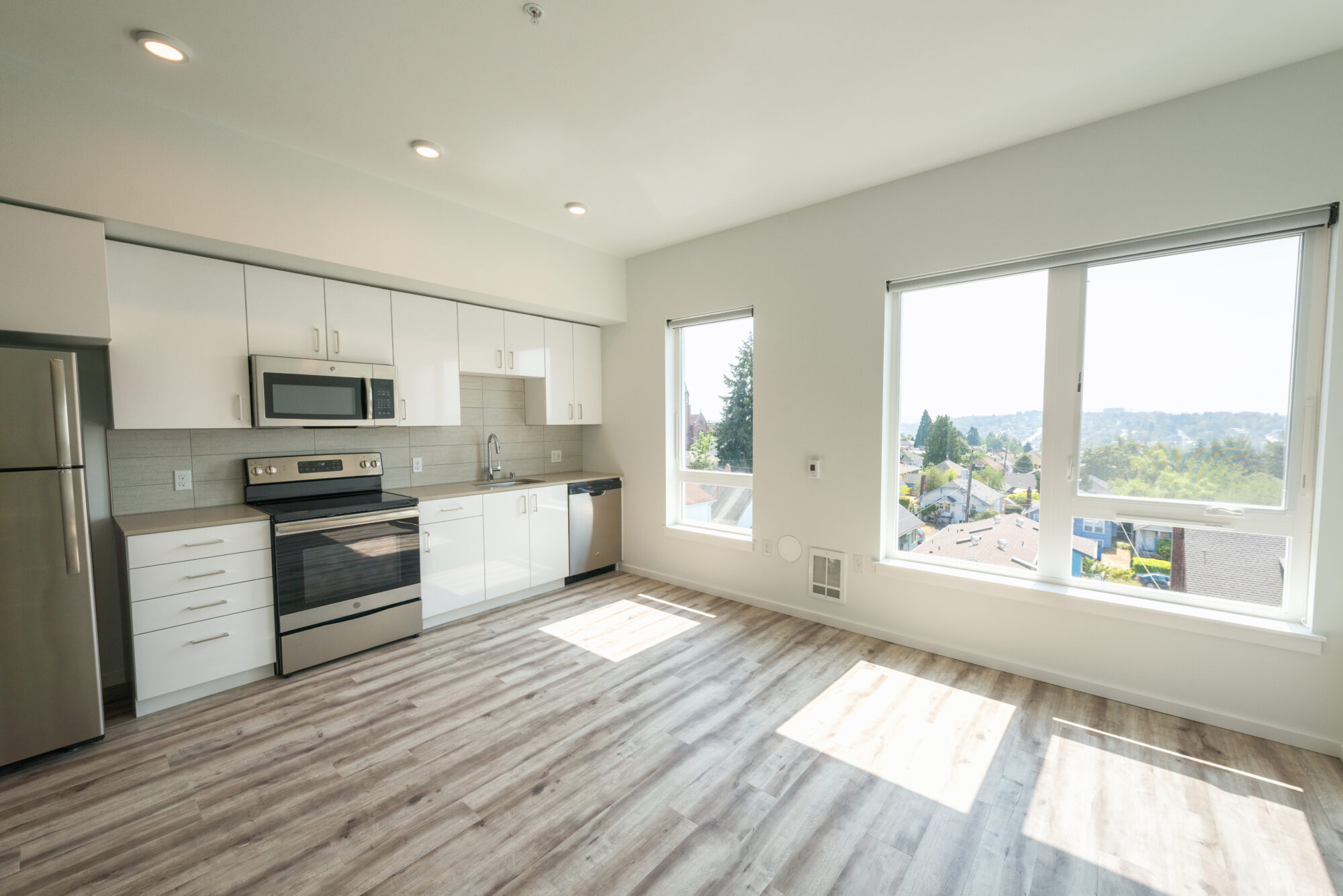 Kitchen with stainless steel appliances and tile backsplash and large windows