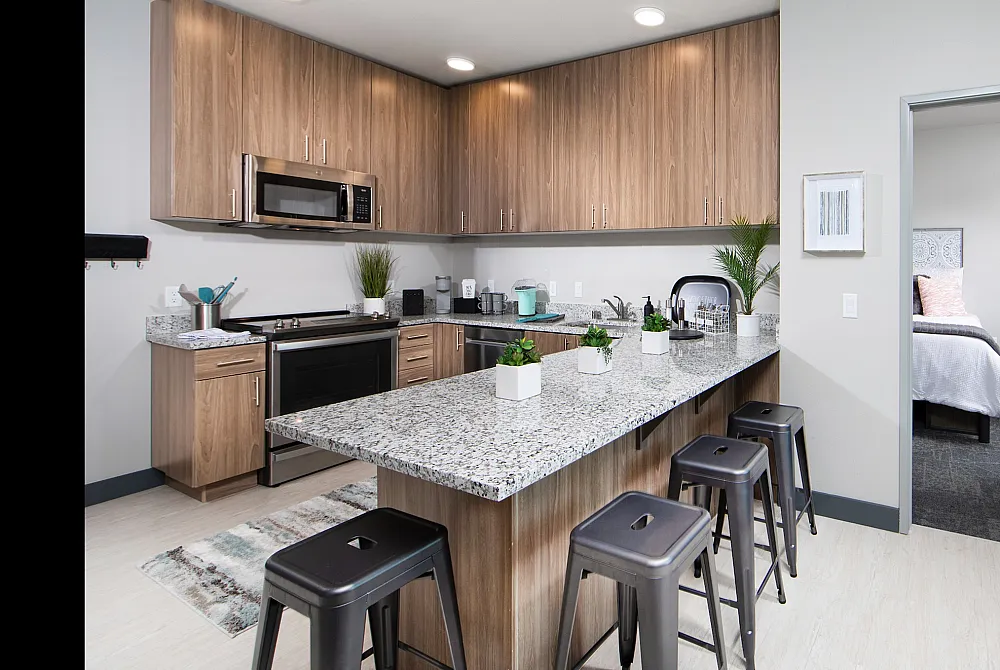 Model kitchen at Hornet Commons apartments in Sacramento, CA, featuring granite countertops and stainless steel appliances.