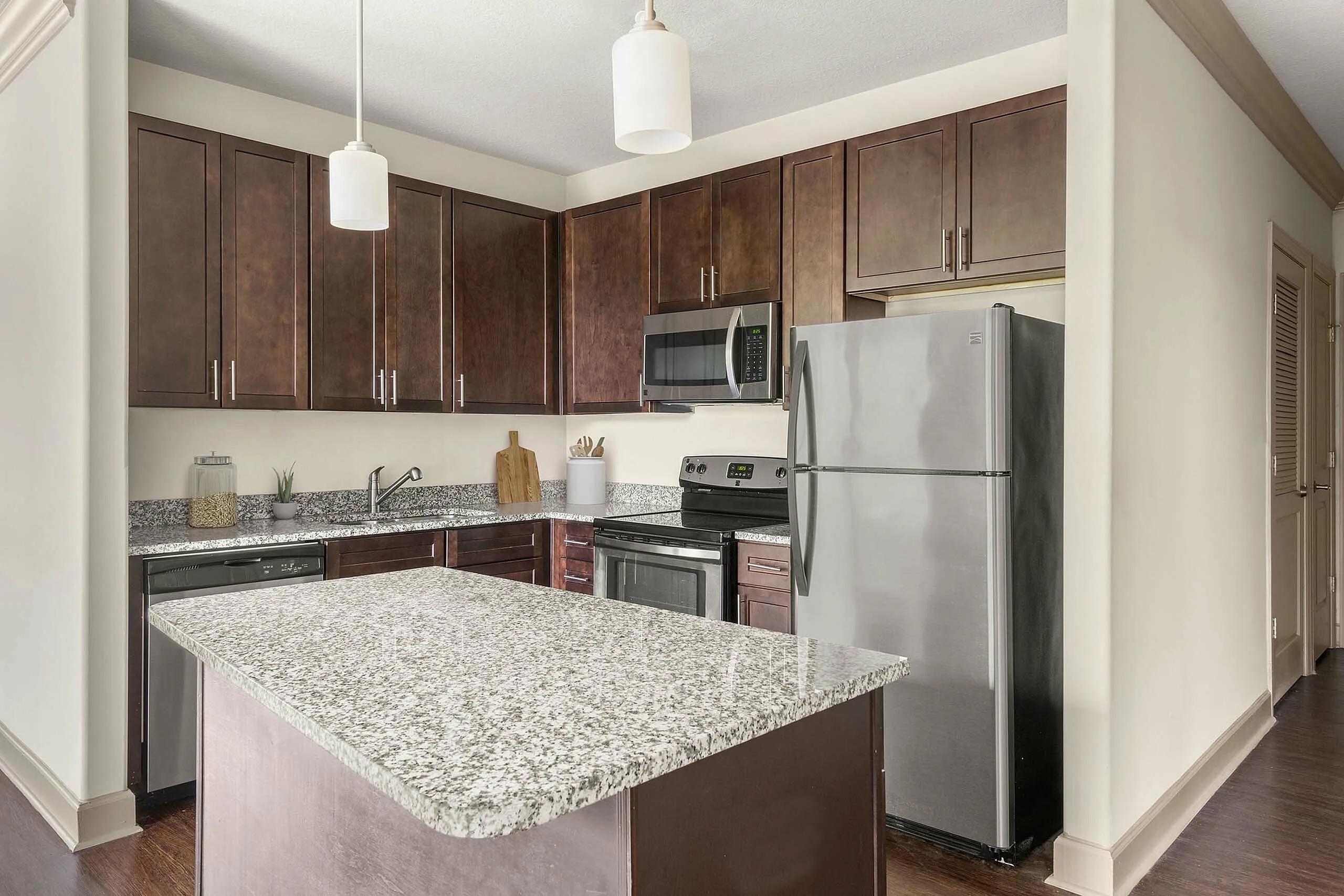 Modern kitchen with sleek stainless steel appliances, elegant granite countertops, and rich wooden cabinetry for a stylish culinary experience.