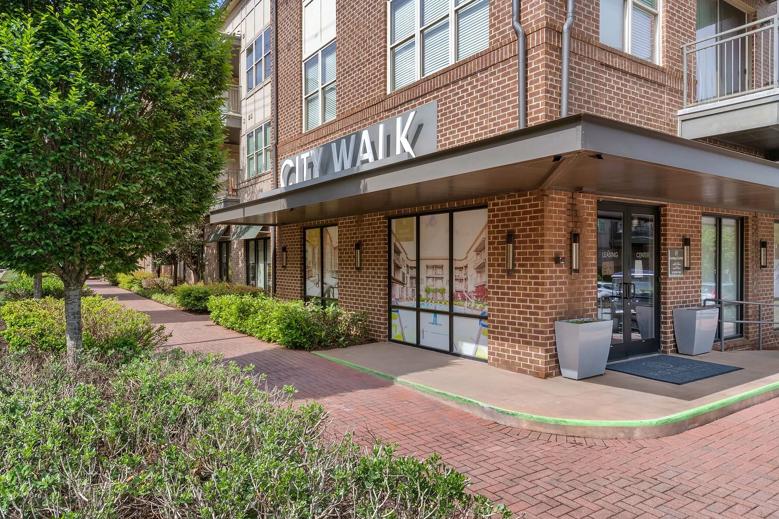 Inviting entrance to City Walk apartments with lush green landscaping and modern architectural design.