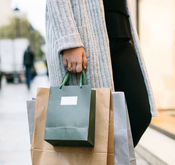 a person holding some shopping bags at The Tribute in Raleigh, 27612