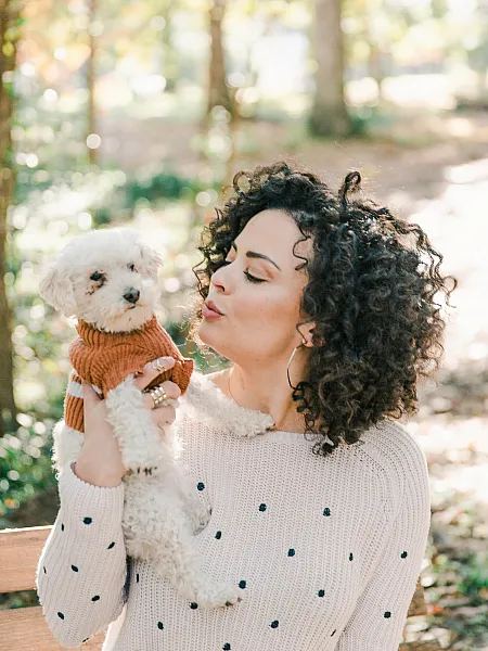 woman holding her dog in a sweater