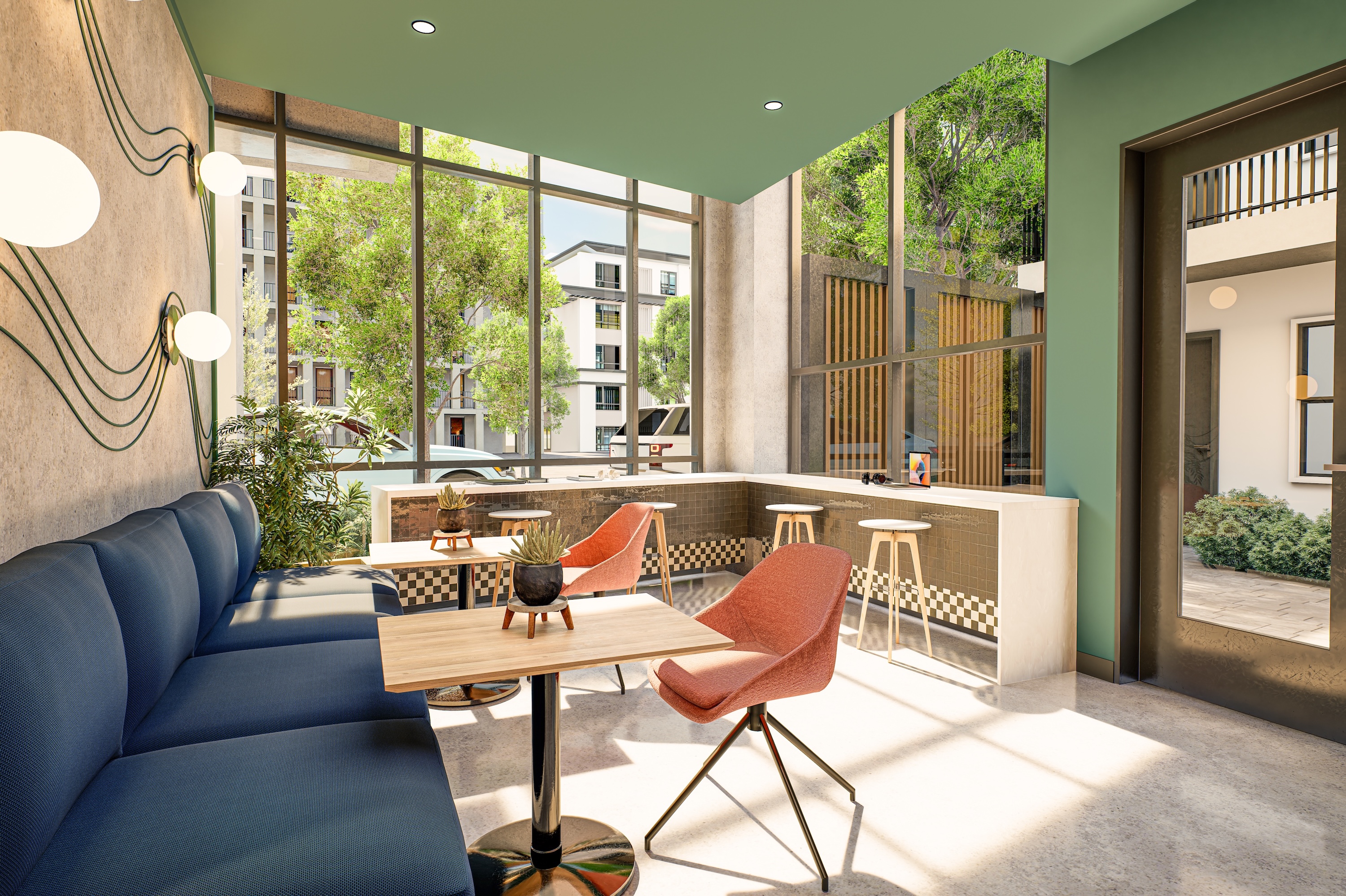 The indoor community lounge with floor-to-ceiling windows offering views of the exterior. The space features a long navy blue built-in couch, wooden tables, and a breakfast bar with modern stools.