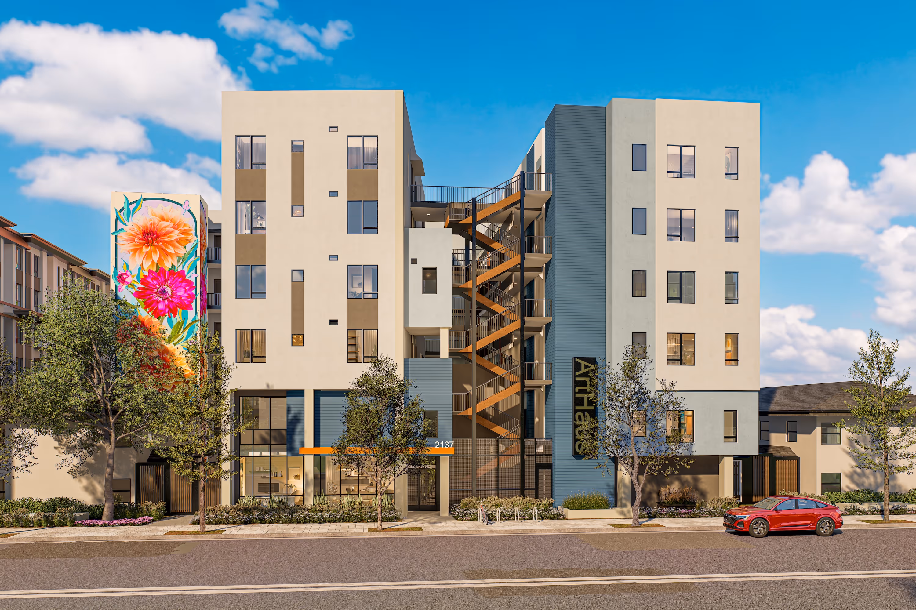 The exterior of ArtHaus Dwight, a multi-story modern apartment building with beige and blue siding, a central staircase, and a large, colorful floral mural on the left side.