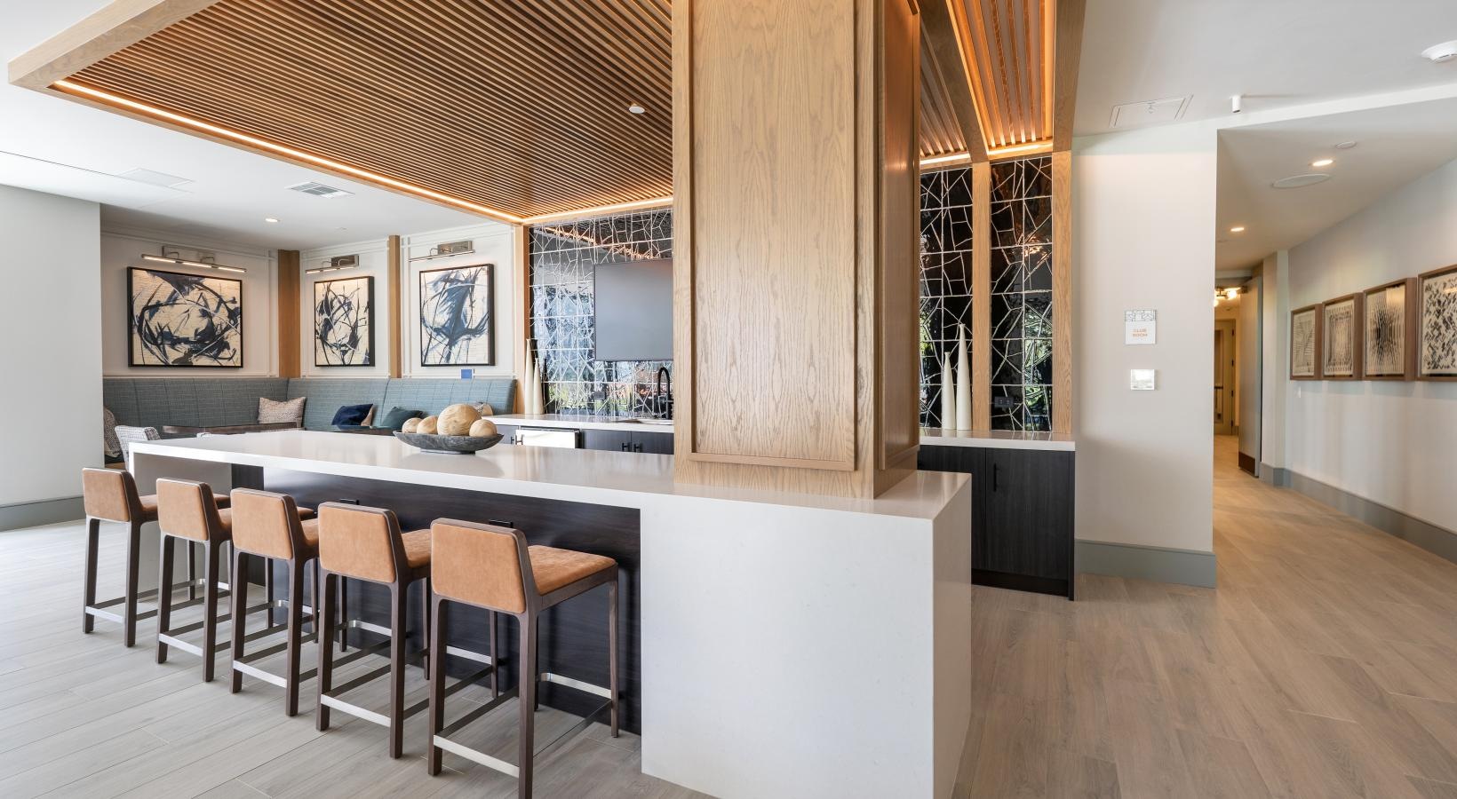 a large kitchen with a bar and chairs