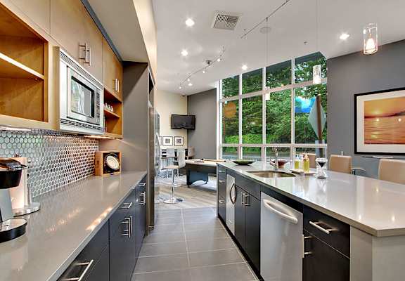 A modern kitchen with a large island and stainless steel appliances.