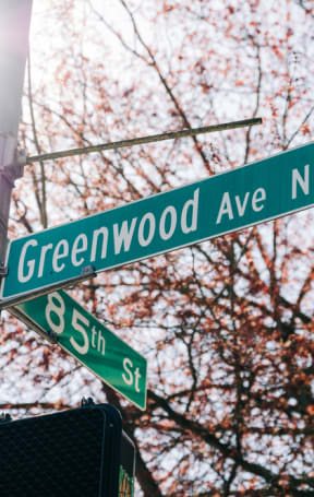 a street sign on the corner of greenwood avenue and 85th street
