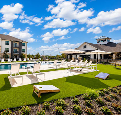 A sunny day at a resort with a pool and lounging area.
