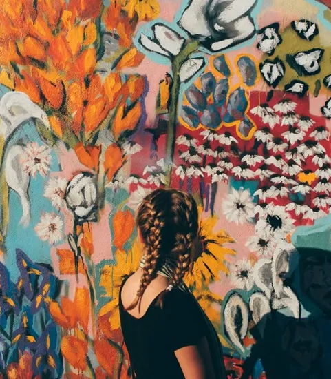 girl in front of mural