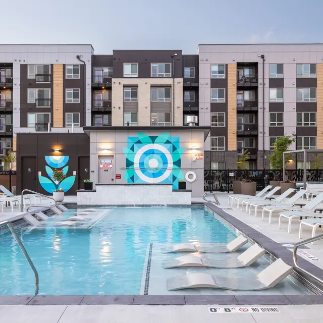 Modern pool area with lounge chairs and colorful mural in the backdrop.