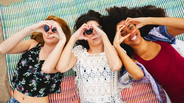 three women lying on blanket on beach