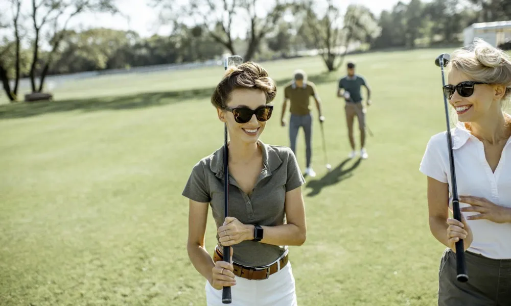 two women and two men on golf course on sunny day