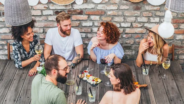 group of people around outdoor table eating meal