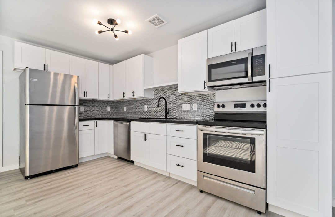 a kitchen with white cabinets and stainless steel appliances