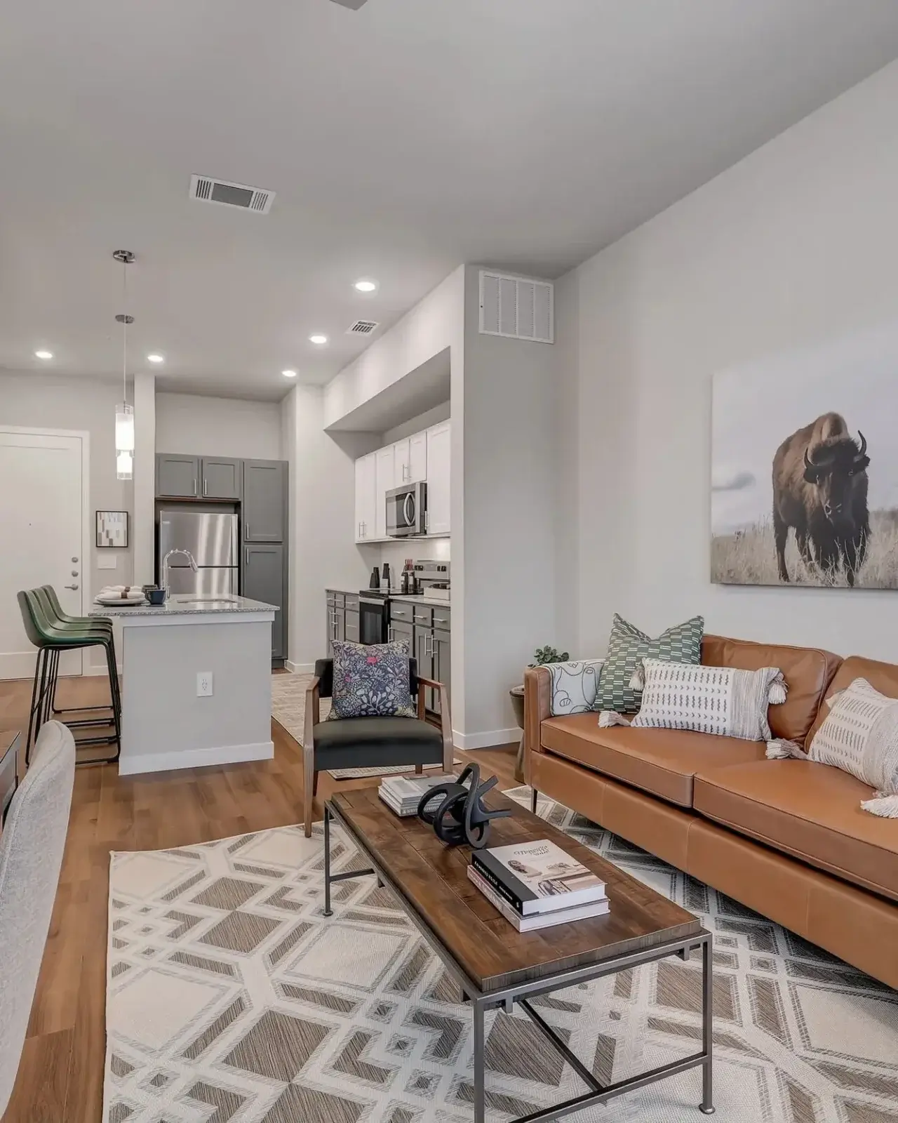 View of the modern living and kitchen area in a luxury Ascend at the Parkway apartment in Katy, Texas