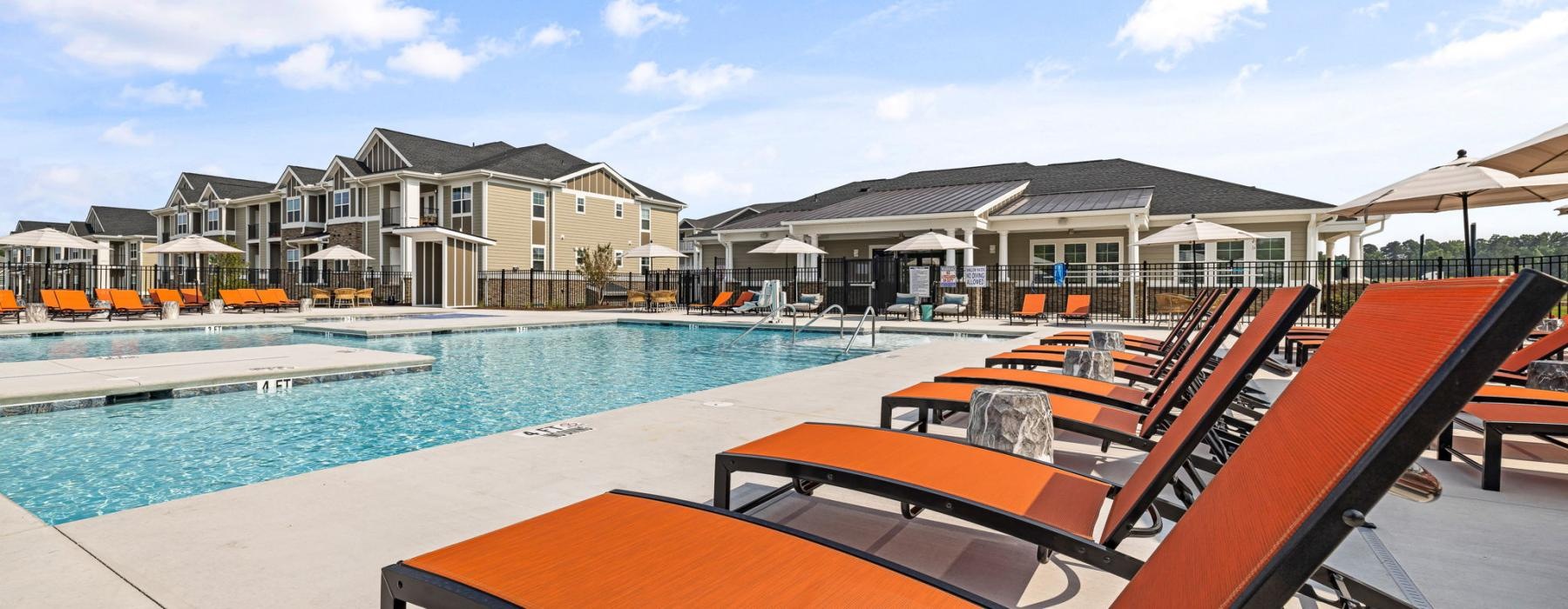 a pool with lounge chairs by it