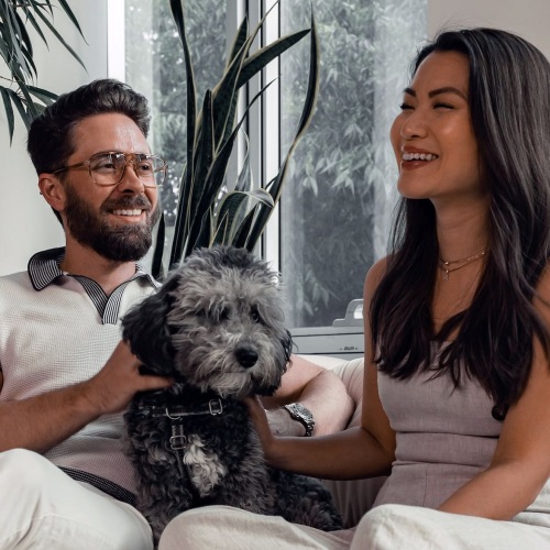 lifestyle image of a couple with their dog within a dim-lit room