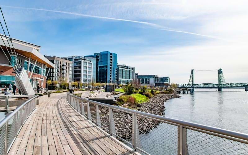 a bridge over a body of water with buildings in the background