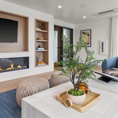 resident lounge with large coffee table chairs fireplace with wall mounted tv
