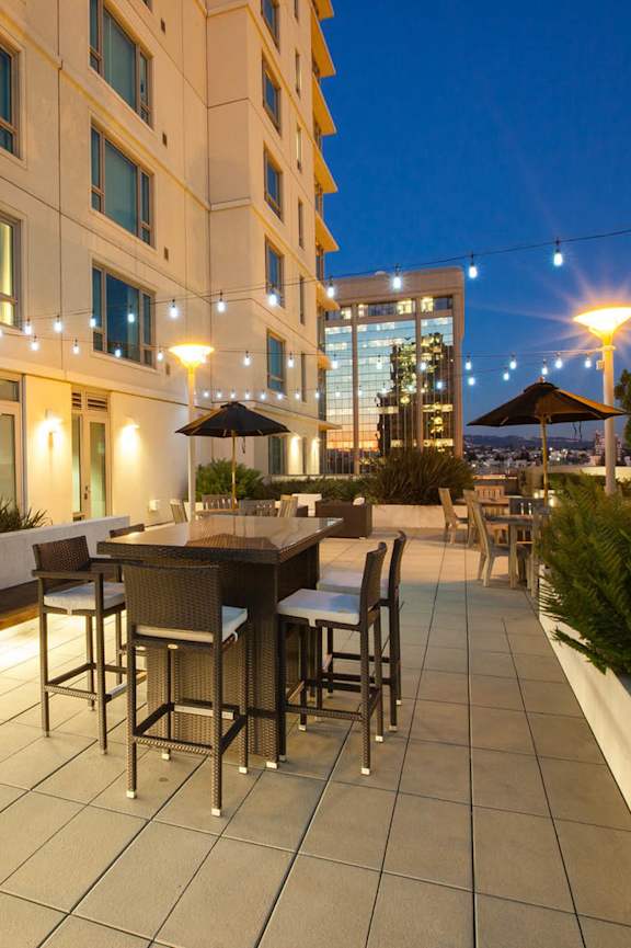 A patio with a table and chairs is lit up at night.
