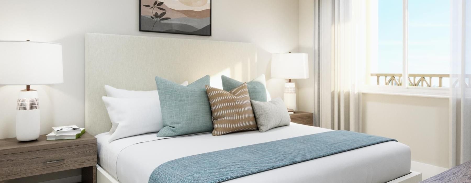 a bed with a blue and white comforter in a room with a window and a lamp