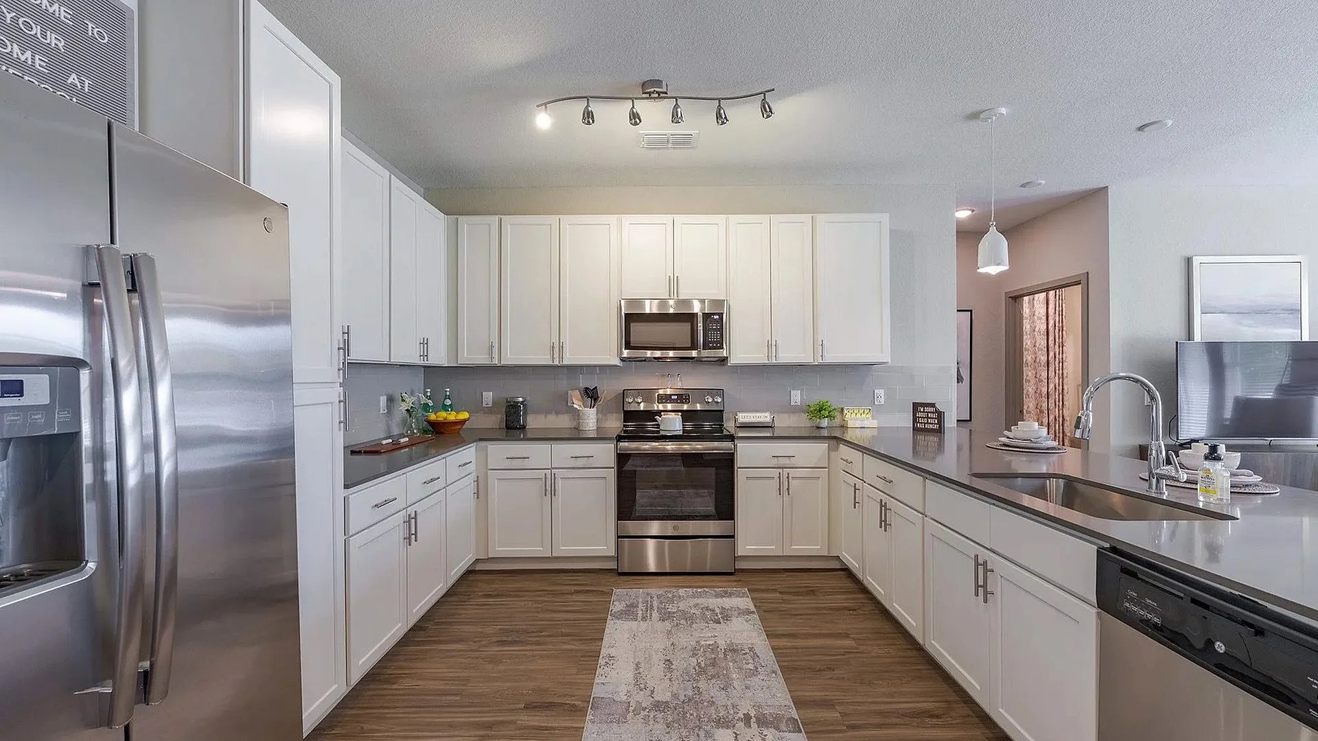 Modern kitchen with stainless steel appliances and white cabinetry.