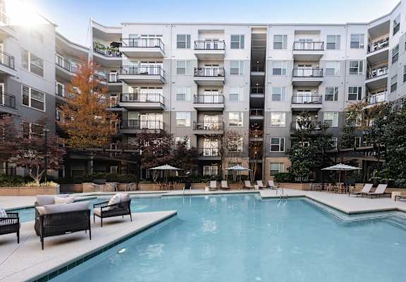 A large swimming pool in front of apartment buildings.