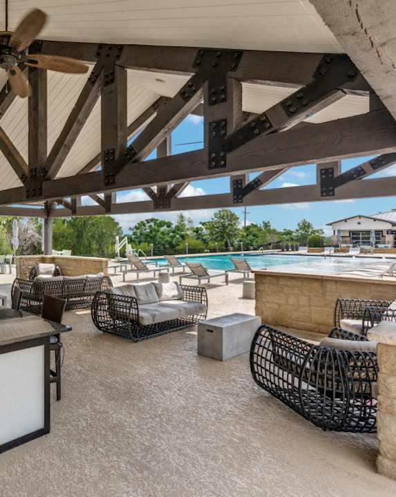 A patio with a table and chairs and a ceiling fan.