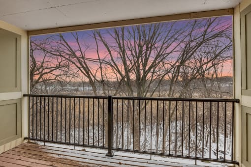 Stratford Wood Apartments and Townhomes in Minnetonka, MN Photo of a balcony with a view of a river at sunset