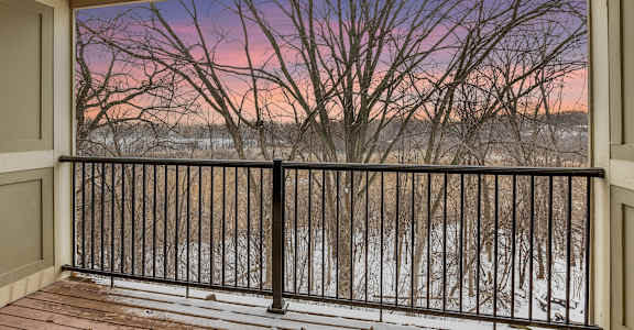 a balcony with a view of a river at sunset