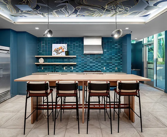 Contemporary kitchen with a sleek island, modern pendant lighting, and vibrant blue tile backsplash.