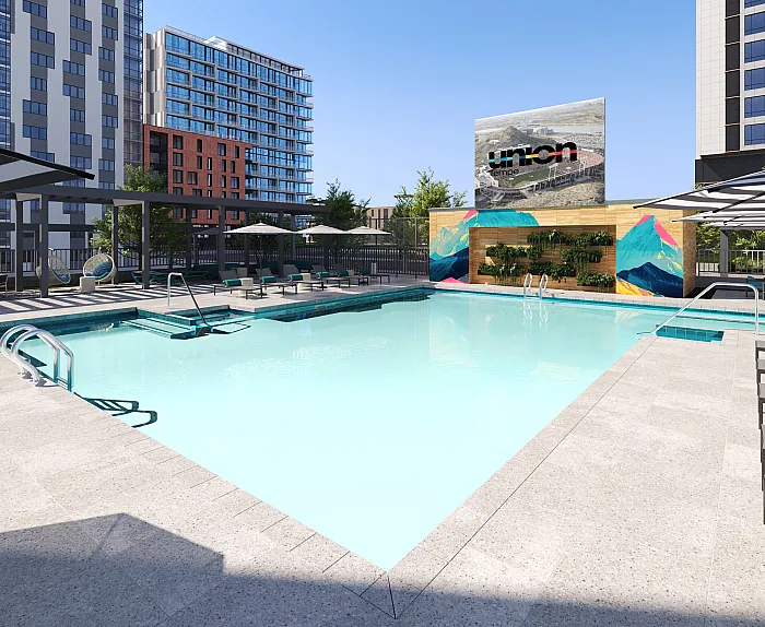 Chic urban apartment complex with a luxurious outdoor pool area, vibrant mural art, and stylish lounge chairs under shaded canopies.
