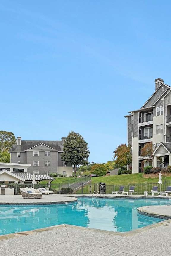 A swimming pool in front of a building with a fence around it.