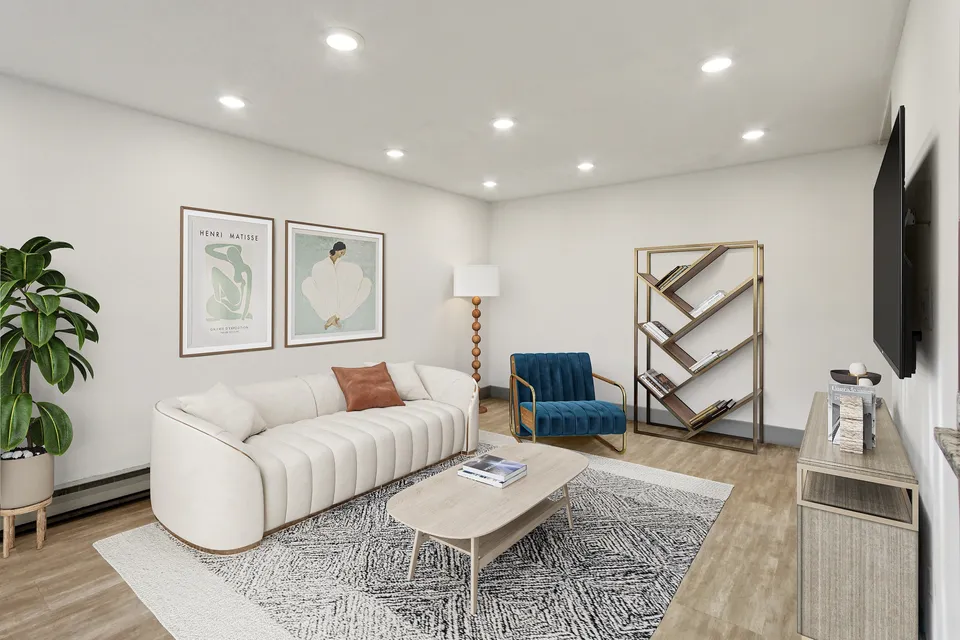 Inviting living room with a chic ivory sofa, modern artwork, stylish bookshelf, and a plush blue accent chair, creating a warm ambiance.