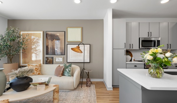 Furnished kitchen and living room in a model unit at Elan Capital Hills Raleigh apartments.