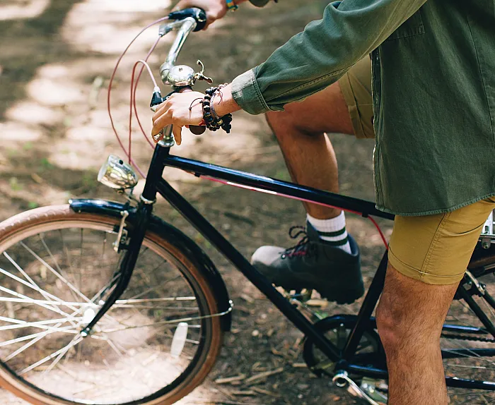 Person riding a vintage bicycle through a scenic forest trail, enjoying an adventurous outdoor experience.