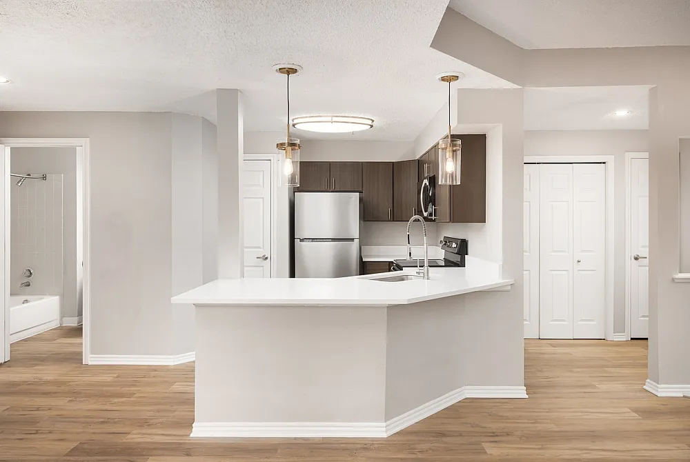 Elegant open kitchen with modern cabinetry, sleek stainless steel appliances, and exquisite lighting, perfect for contemporary living.