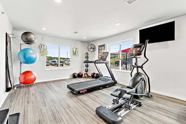 a workout room with treadmills and a flat screen tv at Red Rock Apartments, Rapid City, South Dakota