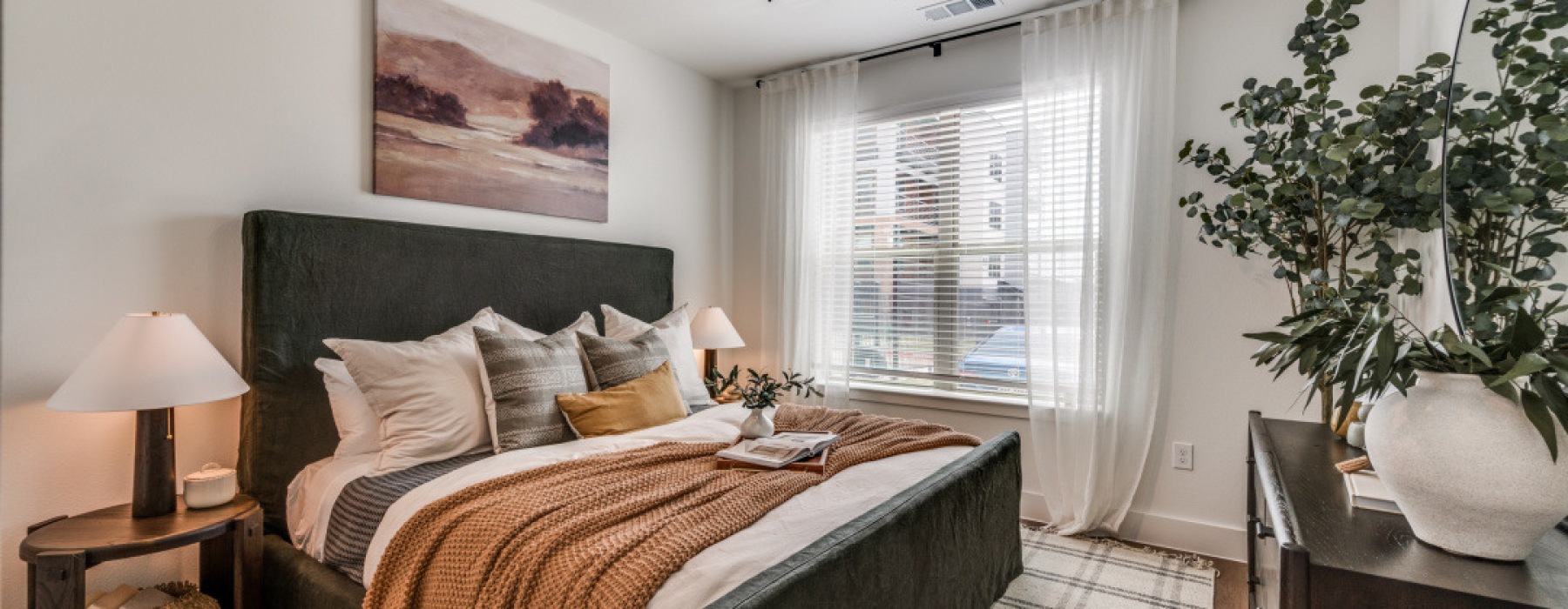 a bedroom with a bed and a plant