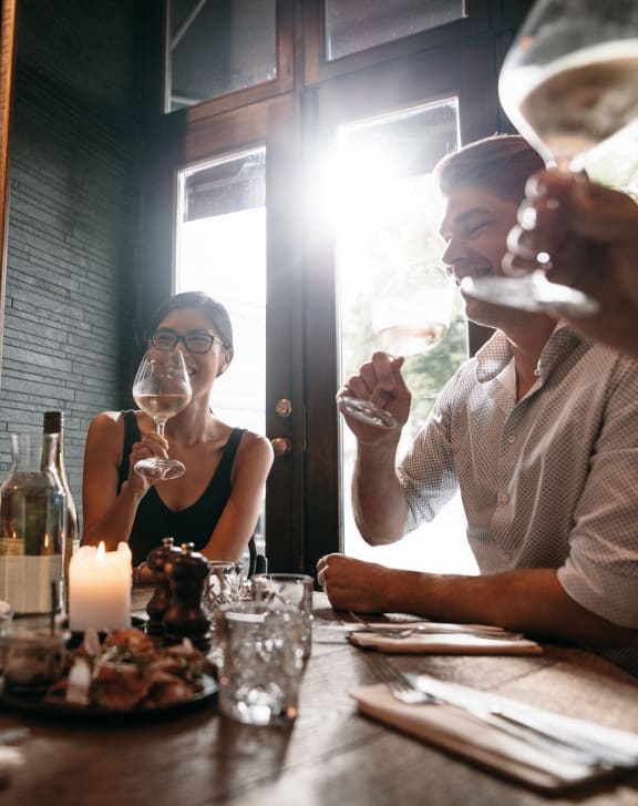 a group of people sitting around a table looking at a cell phone