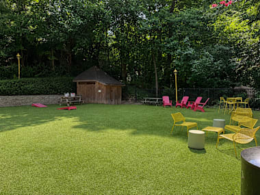 A backyard with a lawn, chairs, and a gazebo.