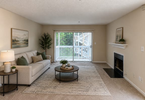 A living room with a couch, coffee table, and fireplace.