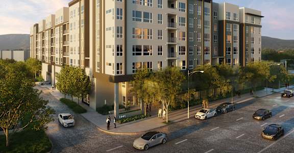 A modern apartment building with cars parked in front.