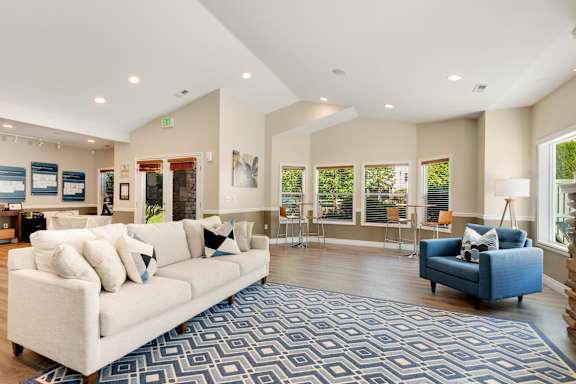 a living room with a white couch and a blue chair