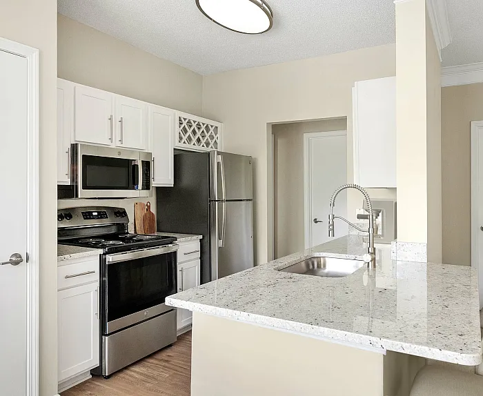 Modern kitchen with stainless steel appliances, elegant granite countertops, and a cozy breakfast bar seating area.
