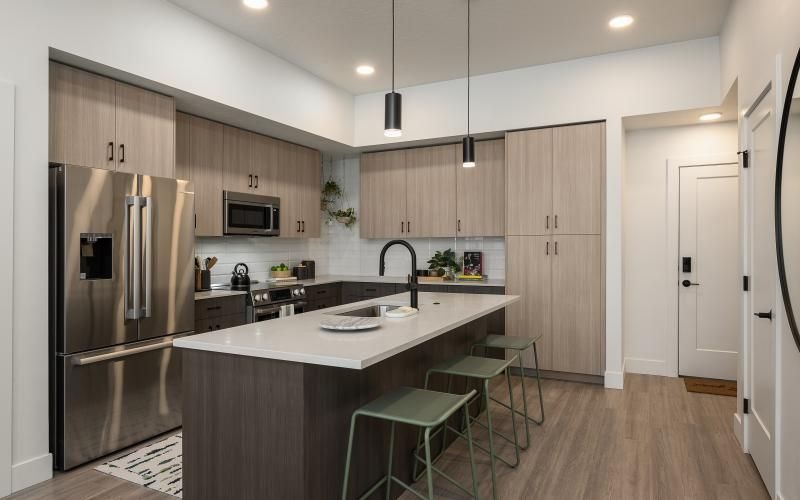 a kitchen with an island bar stools and a refrigerator
