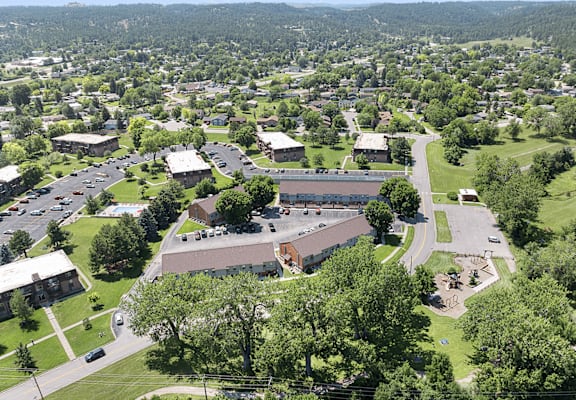 A large building is surrounded by a grassy area and trees.