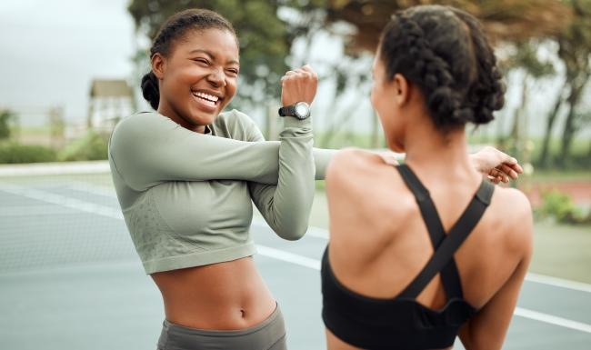 two women stretching outside