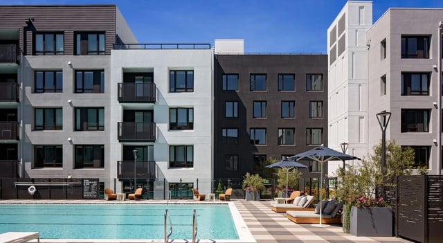 Outdoor swimming pool with lounge chairs and umbrellas.